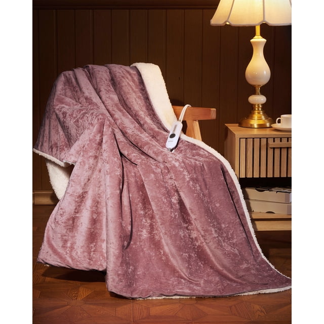 Heated Throw Blanket Electric, Velvet Soft Heating Blanket in iridescent pink with dual-layer softness featuring 220GSM radiant velvet and 210GSM sherpa fleece. Displayed draped over a wooden chair in a cozy room setting, showcasing its plush texture and attached controller. ETL certified with 4 heat settings, 10-hour auto shut-off, and overheat protection. Machine washable for easy maintenance. Available in sizes 50" x 60", 84" x 90", and 90" x 100".