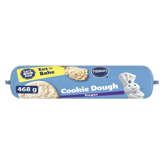 Pillsbury Pâte à Biscuits au Sucre tube de 468 g dans un Emballage Bleu Mettant en Vedette la Mascotte Pillsbury Doughboy, Étiquetée Sécuritaire pour Manger Cru et Manger Ou Cuire, Montrant des Biscuits au Sucre sur l'Étiquette, Convient à la Cuisson Rapide des Fêtes avec de la Pâte à Biscuits Réfrigérée.