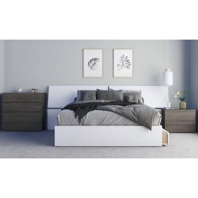 Origin Ensemble de Chambre 4 Pcs avec un Lit de Rangement Blanc avec une Tête de Lit Grand Inclinée et Trois Tiroirs sous le Lit, Habillé de Literie Grise et d'Oreillers, Assorti à une Commode à 4 Tiroirs en Bois Foncé et à une Table de Nuit à 2 Tiroirs, dans une Chambre Minimaliste avec Imprimés Botaniques Encadrés et un Luminaire Suspendu Blanc.
