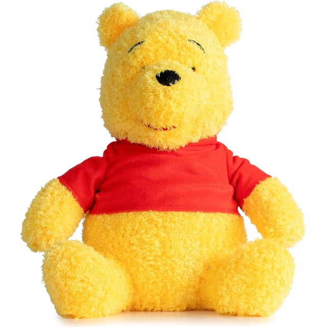 Winnie The Pooh Fuzzy Plush Pillow Buddy featuring a front-facing 14-inch plush pillow of the classic Winnie the Pooh character, crafted from soft yellow polyester velboa with a fuzzy texture and dressed in a red shirt, ideal for kids' bedding and snuggling, also suitable as a travel companion.