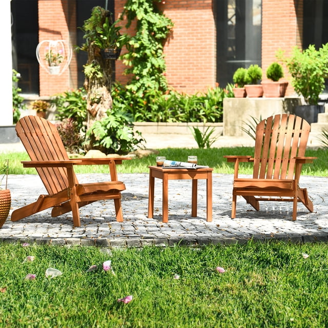Gymax Ensemble de 3 Pcs Eucalyptus Adirondack Chair avec Table d'Appoint Comprenant Deux Chaises Muskoka à Finition Naturelle et une Table Assortie. les Chaises Ont des Dossiers Larges, des Accoudoirs Ergonomiques et une construction durable en Bois d'Eucalyptus avec un design Pliant pour un Rangement Facile. l'Ensemble Est Exposé à l'Extérieur sur un patio en Pierre Entouré de Verdure, Idéal pour les patios, les Jardins Ou la Détente au Bord de la Piscine.