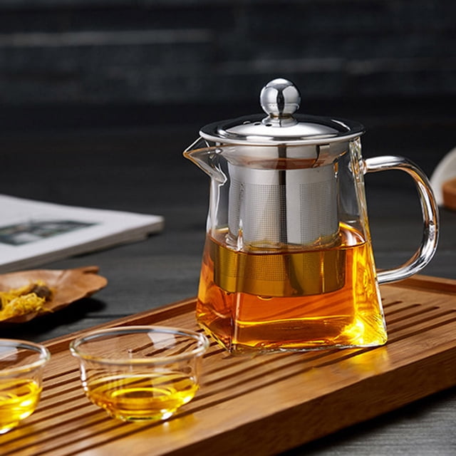 Glass & Bottle Teapot with Strainer Infuser 350ml by Tianyuuuu, designed for brewing loose leaf tea and infusions. Features a durable glass body, stainless steel filter, and ergonomic handle for secure pouring. The teapot prolongs heat retention for optimal flavor extraction and is easy to clean with a removable infuser. Displayed on a wooden tray with two glass cups of tea.