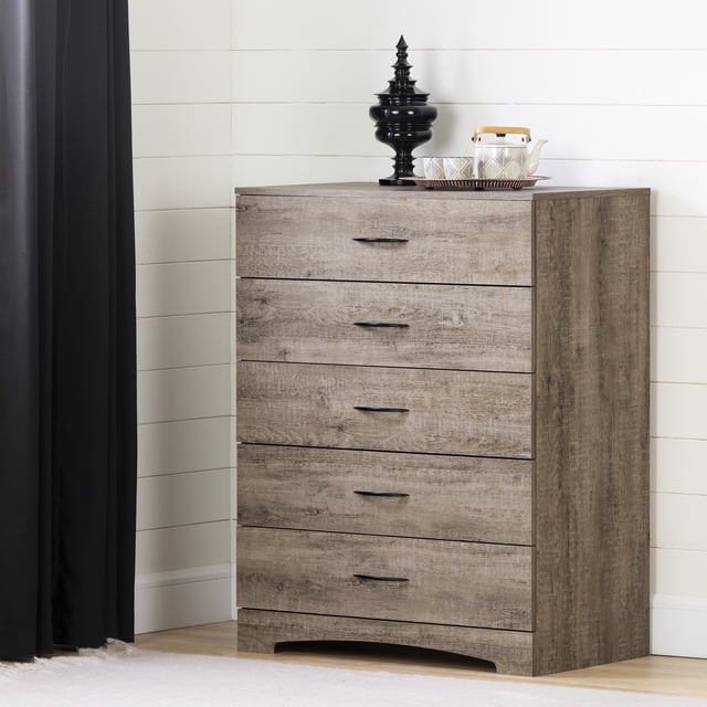 South Shore Step One 5-Drawer Chest for Adult in weathered oak finish with five spacious drawers featuring black metal handles, designed for bedroom storage and organization, standing on a light wood floor against a white shiplap wall, topped with a black decorative urn and a white teapot set on a tray, suitable for compact spaces.