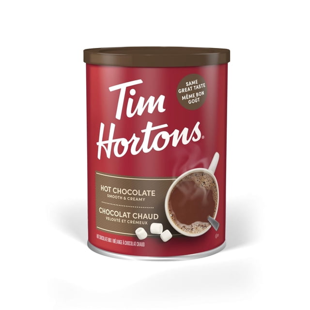 Tim Hortons Hot Chocolate canister with a brown lid and red label featuring the brand name in white script, a steaming cup of smooth and creamy hot chocolate with marshmallows, and bilingual text emphasizing the same great taste. This hot chocolate mix is ideal for enjoying a warm, chocolaty drink at home.