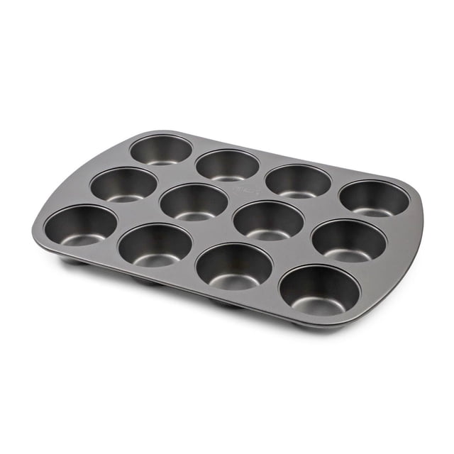 Pillsbury Non Stick 12-Cup Muffin Pan in grey carbon steel with non-stick coating, angled view showing twelve round cups for even baking and quick release, ideal bakeware for muffins or cupcakes, easy to clean and dishwasher safe.