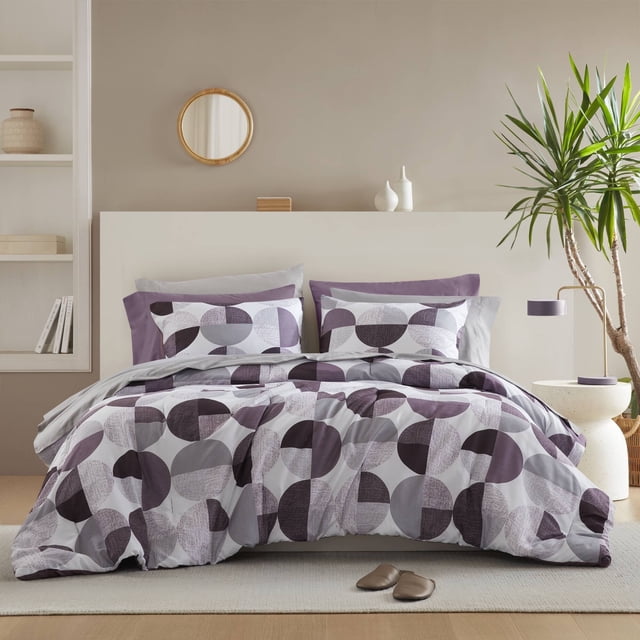Regency Heights Ensemble de Douillette Pleine Grandeur, Ensemble de Lit 9 Pcs Pleine Grandeur, avec un Imprimé Géométrique Rond Violet. l'Ensemble Comprend une Douillette, une Taie Décorative standard, un Drap Plat, un Drap-Housse avec Poches Latérales et Deux Taies d'Oreiller. Fabriqué en Microfibre Douce et Respirante, Il Est Léger et Certifié Oeko-Tex pour la Sécurité. Exposé dans une Chambre Moderne avec des Tons Neutres et une Plante en Pot.