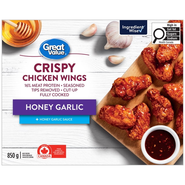 Great Value Ailes de Poulet Croustillantes au Miel et à l'Ail, Plateau de 850 g Orienté vers l'Avant d'Ailes de Poulet Entièrement Cuites et Préassaisonnées avec un Enrobage Croustillant et Collant au Miel et à l'Ail et un Sachet de sauce Séparé sur Fond Blanc Uni, Souvent Utilisé comme Nourriture pour Doigts en Soirée de Jeu Ou comme Service Décontracté pour Fête.