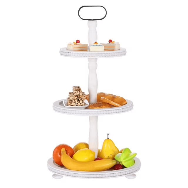 Urban Deco Plateau de Service Rond Décoratif en Bois de Style Ferme Moderne à Trois Niveaux avec Poignée en Métal, Blanc. Ce Plateau en Bouleau Blanc à Trois Niveaux Présente un design Rustique de Style Ferme avec une Poignée en Métal pour une Portabilité Facile. le Plateau Est Montré Tenant un Assortiment de fruits, Pâtisseries et desserts, Mettant en Valeur Sa Polyvalence pour Servir Ou Organiser. Idéal comme Centre de Table Décoratif, Organisateur de Comptoir de Cuisine Ou Porte-Accessoires de Salle de Bain. Facile à Assembler et à Démonter pour un Rangement Pratique.