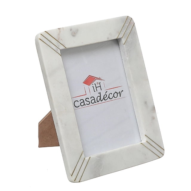 5X7 Marble White With Brass Inlay Picture Frame featuring a rectangular white marble frame with subtle natural veining and brass inlay lines at each corner, designed to hold 5 by 7 inch photos, supported by a brown easel back stand for tabletop display, ideal for modern home décor.