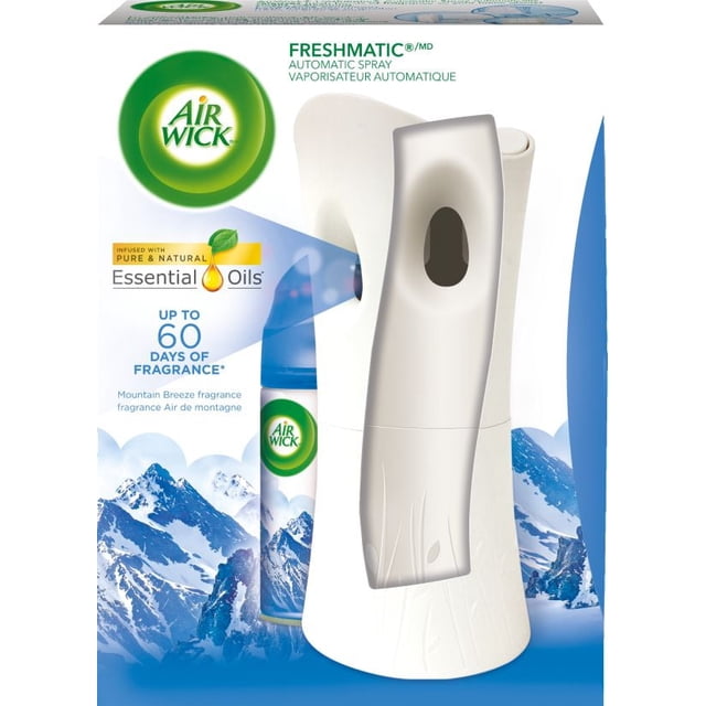 AirWick Freshmatic Air Freshener automatic spray kit in white with a curved body and front spray opening, paired with a Mountain Breeze refill canister featuring blue mountain imagery and a blue cap, delivering up to 60 days of continuous fragrance infused with pure and natural essential oils, suitable for freshening rooms and offices.