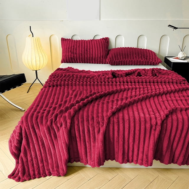 Throw Blanket for Couch Bed Blanket, Compact Flannel Fleece Blanket 100x70cm, shown in a ribbed wine-coloured microfiber design. The blanket is displayed on a modern bed setup with matching pillow covers, emphasizing its soft and cozy texture. Ideal for use on couches, beds, or as a decorative home accessory.