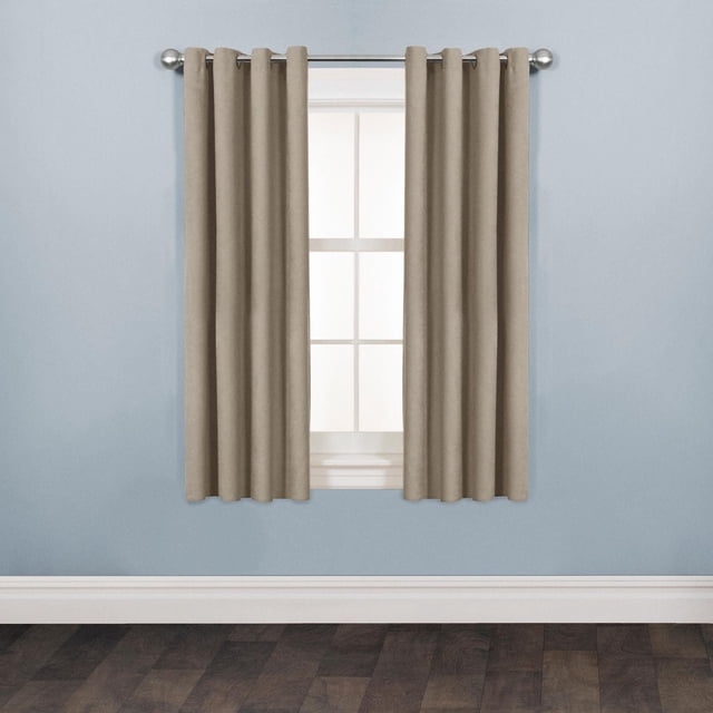 Mainstays Faux Suede Drapery Grommet Window Curtains Panel in beige with soft-touch faux suede texture and matte finish, hanging on a silver curtain rod over a white-framed window set against light blue walls and dark wood flooring, featuring durable 100% polyester fabric and grommet rings for easy installation, ideal for updating room decor.