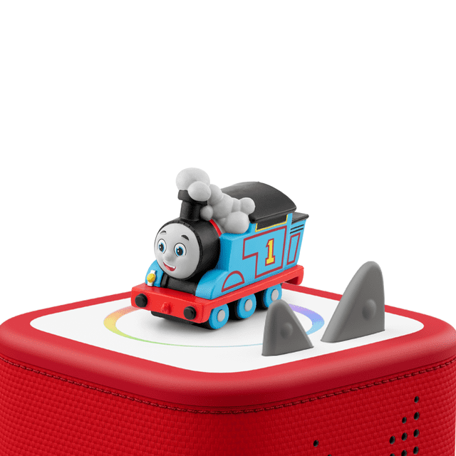 tonies All Engines Go: Thomas Audio Play Figurine - English Only showing a blue and red Thomas the Tank Engine figurine with the number 1 on its side, placed on a red Toniebox speaker with a white top and two gray control ears, designed for screen-free educational play for kids ages 3 and up.