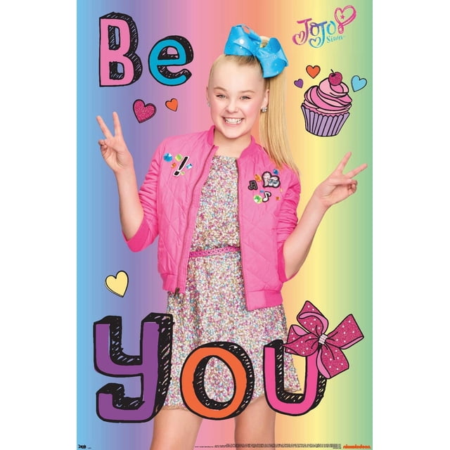 JoJo Siwa - Be You Wall Poster, 22.375" x 34" featuring a front-facing figure wearing a bright pink quilted jacket with colorful patches over a sparkly multicolored dress and a large blue bow in the hair, set against a rainbow gradient background with playful text and graphics including hearts, a cupcake, and the phrase 'Be You'. This poster is suitable for decorating bedrooms, dorms, or party spaces.