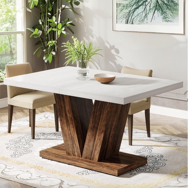 Fnova 47.24" Rectangular Farmhouse Dining Table with a white tabletop and V-shaped brown wood frame. Ideal for small spaces, this modern kitchen table seats 4 people and features adjustable foot pads for stability. Made of waterproof, scratch-resistant engineered wood, it is durable and easy to clean. Shown in a bright dining room with beige chairs and decorative accents.