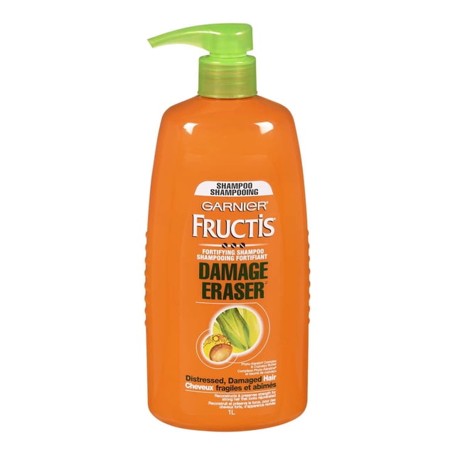 Garnier Fructis Damage Eraser Shampoo in a 1L orange bottle with a green pump dispenser, featuring a Phyto-Keratin complex and cupuaçu butter formula to reconstruct and protect distressed, damaged hair for stronger, shinier hair from root to tip.