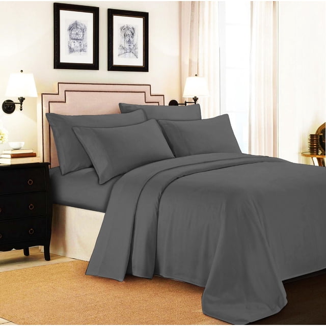Johnson Home 500 Thread Count Certified Organic Cotton Sheet Sets in dark grey on a bed with beige upholstered headboard and nailhead trim, including fitted sheet, flat sheet, and pillowcases, in a softly lit bedroom with cream walls and framed architectural prints.