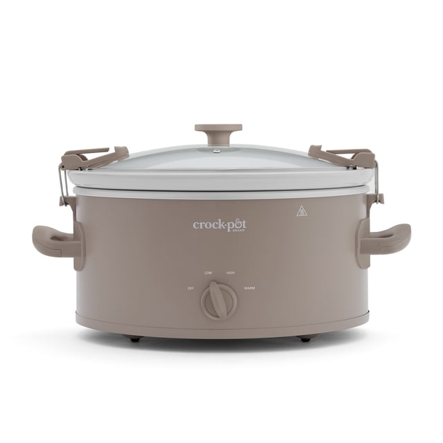 Crock-Pot Design Series 6-Quart Manual Slow Cooker in Alpaca Brown with an oval shape, glass lid secured by travel-proof locking clips, side handles, and a front dial with Off, Low, High, and Warm settings, suitable for cooking and carrying meals.