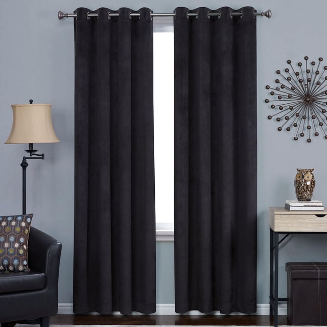 Hometrends Velvet 84" Grommet Blackout Window Curtains Panel in black velvet fabric with metal grommet top, hanging on a curtain rod in a living room setting, designed to block light, reduce noise, and provide privacy while saving energy and reducing drafts.