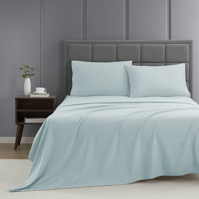 Nestl Split King Sheet Set, 1800 Series Microfiber Deep Pocket 4 Piece Bed Sheet Set in light blue, displayed on a neatly made bed. The set includes two pillowcases, a flat sheet, and two fitted sheets, crafted from hypoallergenic and breathable microfiber fabric for a serene sleeping experience. The bed features a grey upholstered headboard and a modern nightstand with a white vase and cup, suitable for toddler bedding setups.