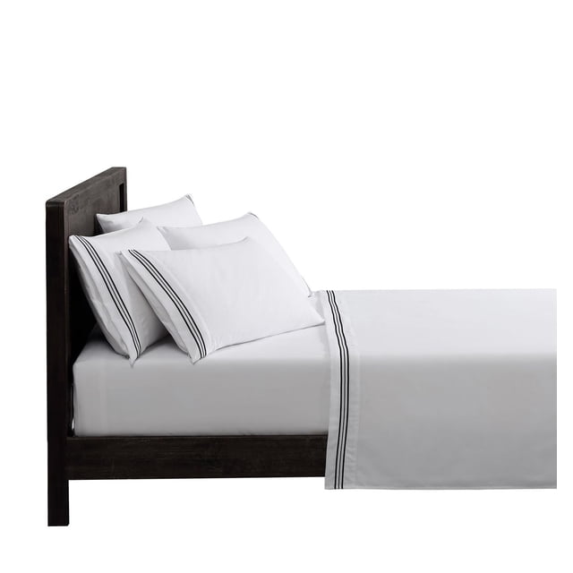 Hometrends Super Soft Embroidered Luxury Sheet Set 6pcs on a dark wood bed frame, featuring white microfiber sheets and pillowcases with embroidered black stripe trim, including a deep pocket fitted sheet and four pillowcases, wrinkle and fade resistant, easy care, and suitable for year-round use.