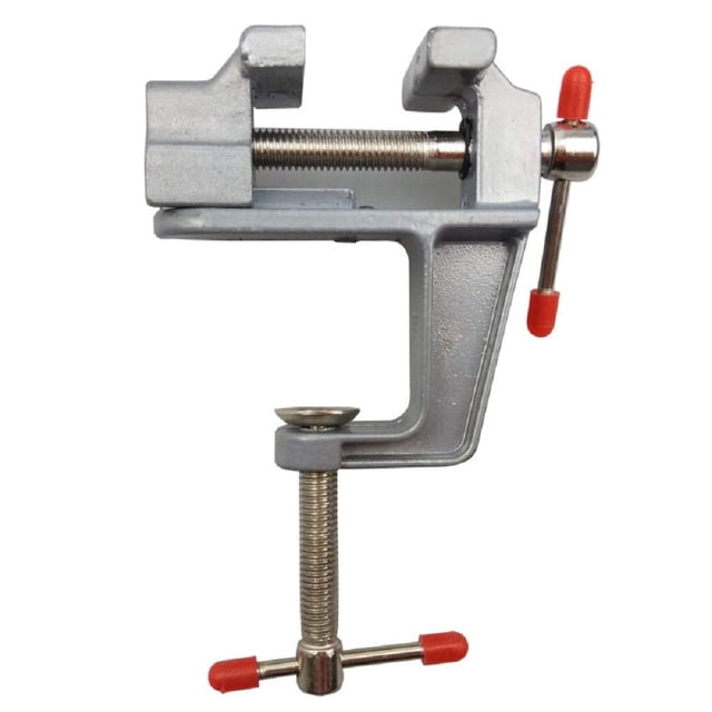 1.5in Mini Alloy Aluminum Vise Precision Bench Jewelry Clamp Vice Light Table Vice by TOPZONE. A compact and lightweight silver aluminum vise with red rubber-tipped handles and a screw clamp mechanism for secure attachment to a table surface. Ideal for woodworking tasks such as sanding, grinding, drilling, and carving. Weighs 4.8 ounces and features a 1.5-inch jaw opening for small projects.