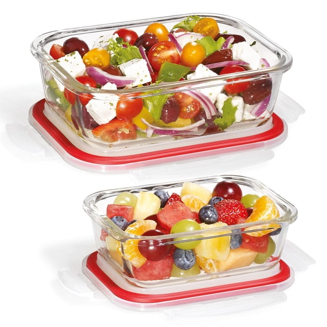 Starfrit LocknLock Glass 4-piece rectangular container set with clear borosilicate glass containers and red airtight lids, one filled with mixed vegetable salad including cherry tomatoes, red onion, olives, and feta cheese, the other with assorted fresh fruit like grapes, blueberries, strawberries, pineapple, watermelon, and orange segments, oven, microwave, freezer, and dishwasher safe, suitable for storing, reheating, and serving food.
