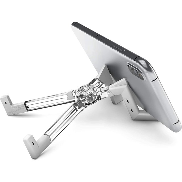 KEKO Universal Foldable Tablet Stand in black holding a silver tablet in landscape orientation, featuring a transparent polycarbonate X-shaped design with foldable arms and anti-slip rubber tips, providing ergonomic and portable support, also suitable for smartphones and e-readers.
