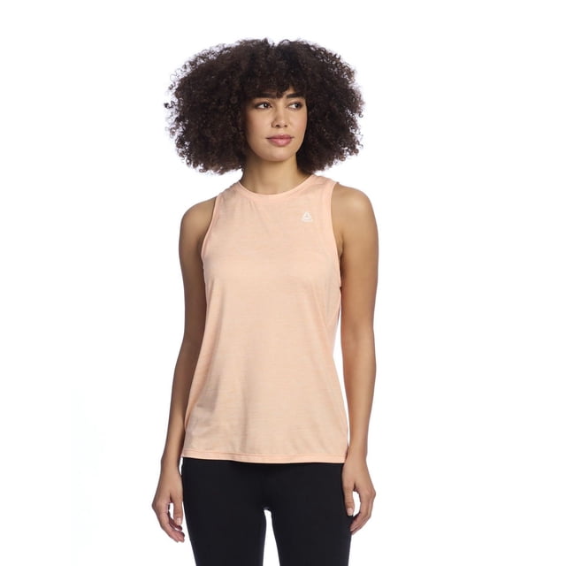 Reebok Women’s ‘Legacy’ Tank Top in light peach, sleeveless with a classic crew neckline, made from a breathable 78% recycled polyester blend, featuring a small white Reebok Delta logo on the upper left chest, suitable for workouts, running errands, or casual layering, shown on a front-facing model wearing black leggings.