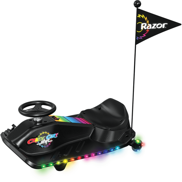 Crazy Cart Shift Lightshow par Razor, un go-kart de Dérive Électrique 12V pour Enfants de 6 Ans et Plus, Montré sur une Vue Latérale. le go-kart Noir Présente un Siège de Style Seau, un Volant et des Lumières DEL Multicolores Vibrantes le Long du Châssis et des Roues Pivotantes Arrière. Il Comprend un Drapeau de la Marque Razor et Est Conçu pour des Vitesses Allant jusqu'à 8 Mi/h avec un Commutateur de Contrôle de Vitesse parental. le Cadre Léger et le Système de Dérive Simplifié