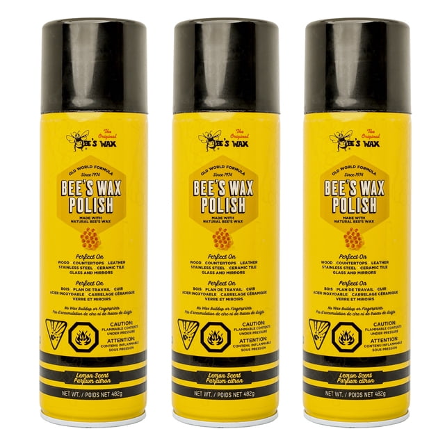 The Original Bee's Wax Old World Formula Furniture Polish in a 482g aerosol spray can with a bright yellow label and black cap. The label highlights its versatility for cleaning and polishing wood, countertops, leather, stainless steel, ceramic tile, glass, and mirrors. The product is noted for its anti-static properties, lemon scent, and ability to prevent fingerprints and soap scum buildup. Sold since 1974, it is described as a multi-surface cleaner and polish.