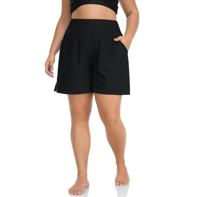 Charmo Shorts de Bain Grande Taille pour Femmes, Shorts de Planche Taille Haute, Bas de Tankini avec Poches. Ces Shorts de Bain Noirs Comportent une Taille Haute de 2,7 Pouces avec Grand Ceinture pour le Contrôle du Ventre, une Entrejambe de 5,5 Pouces avec Fente en V pour la Libre Circulation, et Deux Poches Latérales Adaptées pour Tenir des Articles Personnels comme un Téléphone de 6,7 Pouces. Fabriqués à Partir de 82 % de nylon et 18 % d'Élasthanne, les Shorts Comprennent une Doublure Boxeur Intégrée pour Anti-Frottement et Résistance au Sable