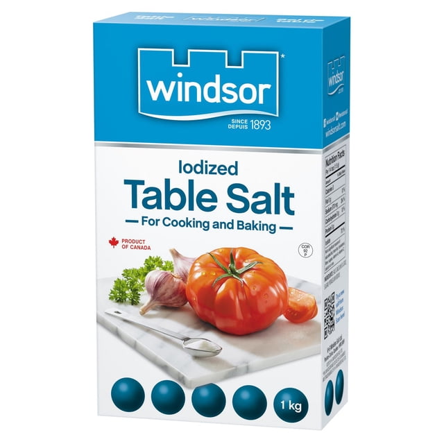 Windsor® Iodized Table Salt 1 kg box with blue and white packaging featuring the Windsor logo, labeled for cooking and baking, showing a fresh tomato, garlic cloves, parsley, and a spoonful of salt on a marble cutting board, product of Canada.