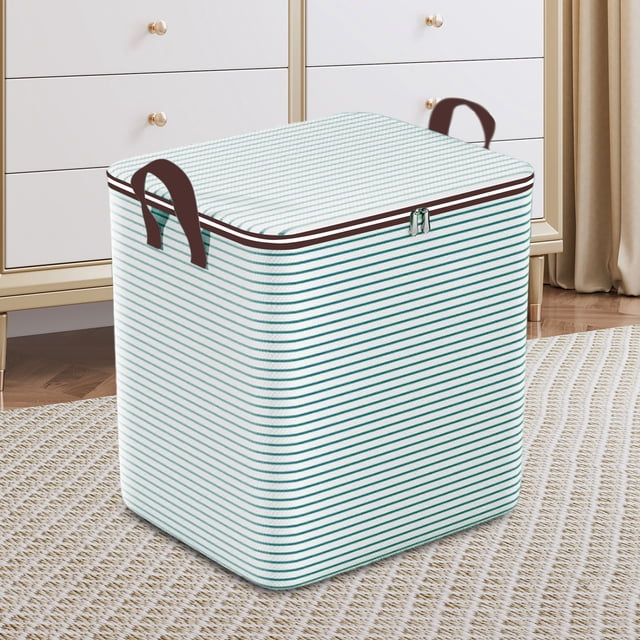 Boîte de Rangement pour Vêtements pour Déménagement à Domicile, Grande Capacité, Boîte de Rangement pour Garde-Robe et Vêtements, Panier de Rangement à l'Épreuve des Sacs. la Boîte Présente un design à Rayures avec une Fermeture Éclair Bidirectionnelle et des Poignées Renforcées des Deux Côtés pour un Transport Facile. Elle Est Pliable pour un Rangement Gain de Place et Fabriquée en Matériau Léger et Sans Odeur. Montrée dans un Décor de Maison sur un Tapis Texturé avec une Commode en Arrière-Plan.