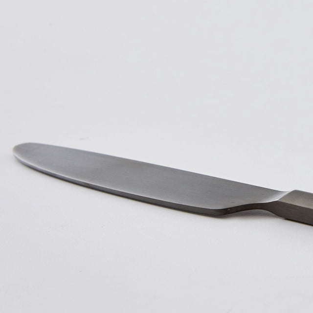 BHG River Black Satin Dinner Knife shown in close-up side profile on a white background, featuring a stainless steel blade with satin black finish and ergonomic handle, suitable for flatware and dining table use.