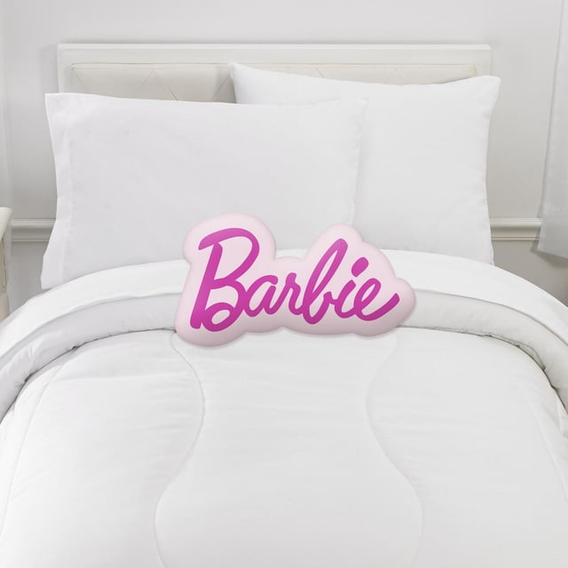 Barbie Barbie « Logo » Coussin Câlin avec Inscription Rose Vif sur un Coussin en Peluche Rose Pâle, Affiché sur un Lit Blanc avec des Coussins Blancs et de la Literie dans une Chambre Propre et Minimaliste. Ce Coussin Décoratif Ajoute une Touche de Confort en Peluche Rose Barbie et Douce à la Déco de la Maison, Idéal pour Se Détendre Ou Voyager.
