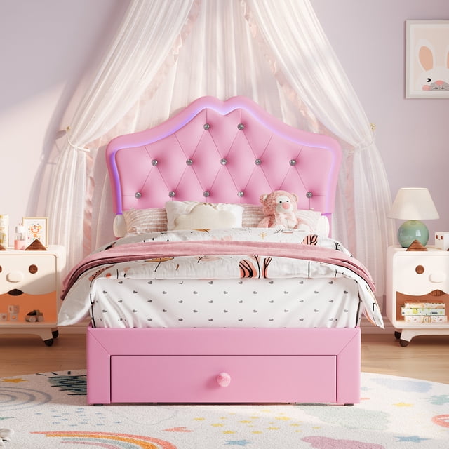 EDTara Twin Size Princess Bed Frame with Storage Drawers & LED Lights, featuring a pink velvet upholstered platform design with a castle-shaped PU leather headboard adorned with crystal buttons. The bed includes a large storage drawer at the foot, built-in LED lighting with 1600 color options and music-synchronized modes, and a noise-free sturdy frame that requires no box spring. Ideal for kids' bedrooms, combining style, comfort, and practicality.