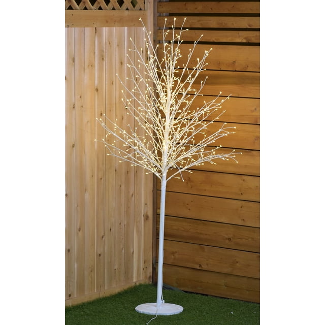 Arbre de Noël à Micro-Point Blanc de 6,8 Pi H avec 1300 DEL Blanc Froid, Convient à une Utilisation Intérieure et Extérieure. Fabriqué en Cuivre, Résine et Fer, l'Arbre Présente des Lumières à Micro-Point pour une Lueur Chaleureuse des Fêtes. Positionné sur une surface Gazonée avec un Fond de Clôture en Bois.