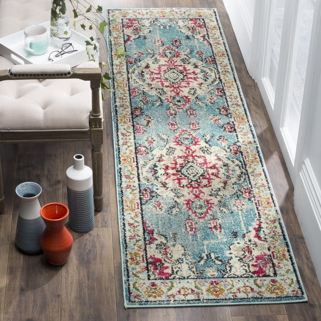 Safavieh Monaco Toria Tapis Traditionnel de Forme Rectangulaire avec des Tons Bleus et Crème Accentués de Motifs Floraux et Géométriques d'Inspiration Persane Rouge et Rose, Empilage en Polypropylène Tissé Mécaniquement sur Plancher de Bois à Côté d'Une Chaise Coussinée beige et des vases Décoratifs, Souvent Utilisé pour Rehausser des accents Bohèmes Chics pour la Maison.