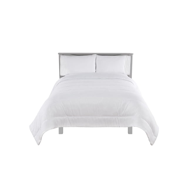 Mainstays Couette Gaufrée en Duvet Synthétique Blanche Affichée sur un Lit avec une Tête de Lit Grise, Mettant en Valeur Deux Oreillers Blancs et la texture en Microfibre Gaufrée de la Couette, Conçue pour une Chaleur Toutes Saisons et Convient comme Rembourrage de Housse de Couette.