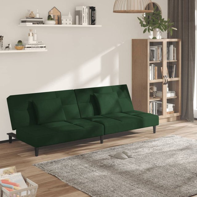 vidaXL 2-Seater Sofa Bed with Two Pillows in dark green velvet, displayed in a contemporary living room. The sofa has a soft velvet finish, a sturdy wooden frame, and includes two square pillows. It easily converts into a bed with dimensions of 200 x 100 x 32 cm, offering a maximum load capacity of 110 kg per seat. The room features a light grey rug, wooden flooring, and a bookshelf in the background.