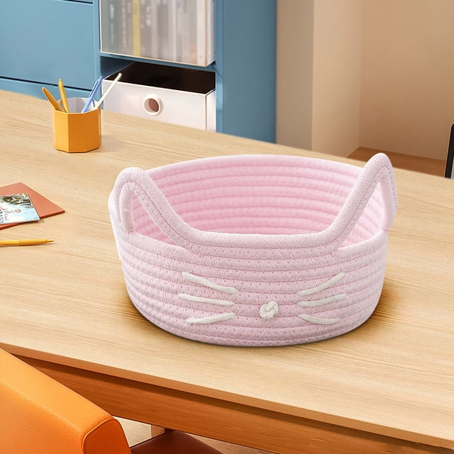 Cats Ear Cottons Thread Organizer Basket designed for office, household, and desk organization. This pink woven desktop organizer box features a soft cotton rope construction with cat ear-shaped handles and embroidered whisker details on the front. Ideal for storing cosmetics, snacks, sundries, or small office supplies. Displayed on a wooden desk in a modern office setting with bookshelves and stationery in the background.