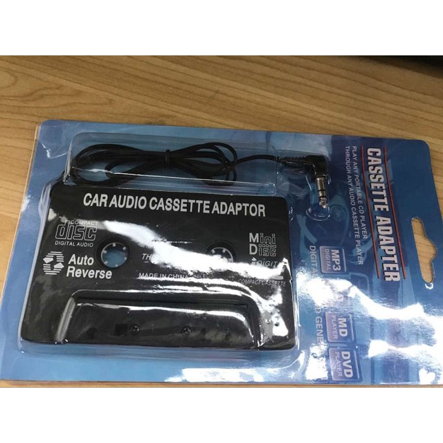 TIMIFIS 3.5mm AUX Car Audio Cassette Tape Adapter Transmitters for MP3 and iPod, shown in its retail packaging. The black cassette-shaped adapter features a 3.5mm audio jack and a 40-inch cord for connecting devices like CD players, MiniDisc players, or iPhones to a car's cassette player. The packaging highlights compatibility with MP3, CD, and MiniDisc players, and includes features like auto-reverse and silent mechanism for reduced noise. Ideal for car audio systems.