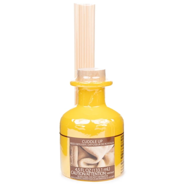 ScentSationals Reed Diffuser - Cuddle Up with a yellow glass bottle containing 4.5 fl oz (133.1 mL) of essential oil infused with cedar, patchouli, pink peppercorn, nutmeg, mandarin leaf, and vanilla tonka, topped with a wooden cap and eight natural reed sticks for home aromatherapy.