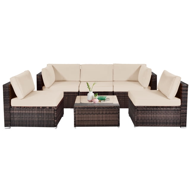 Patiojoy 6PCS Wicker Patio Sectional Conversation Furniture Set with Coffee Table & Seat Cushions in brown. The set includes 2 armless sofas, 2 corner sofas, and 1 coffee table with a tempered glass top. Made with a sturdy steel frame and premium PE wicker, it features thick padded beige cushions for comfort. The modular design allows for versatile arrangements, suitable for outdoor or indoor use. The coffee table has a detachable glass top and aluminum foot pads prevent scratches.