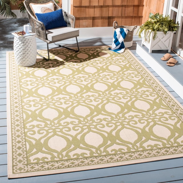 Safavieh Courtyard Tapis d'Extérieur Géométrique Colton avec Motif Géométrique Répétitif beige et Vert olive et Bordure Décorative, Fabriqué en Polypropylène durable pour un Entretien Extérieur Facile, Exposé sur une Terrasse en Bois Bleue avec une Chaise en Osier, une table d'Appoint Blanche et des Plantes, Idéal pour patios Ou Vérandas.