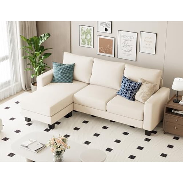 Homall Canapé Sectionnel Convertible, un Sofa Moderne en L à 3 Places avec Méridienne Réversible, Rembourré en Tissu de Lin beige Doux. le Sofa Présente un design compact, Idéal pour les Petits Salons, Appartements Ou studios. l'Ottoman Peut Être Positionné des Deux Côtés pour la Flexibilité. les Coussins Sont Remplis de Mousse à Haute Densité et de Ressorts Hélicoïdaux pour le Confort et le Soutien. le Cadre en Bois Robuste Assure la Durabilité. Montré dans un Salon Lumineux avec des Coussins Décoratifs et un Tapis à Motifs.