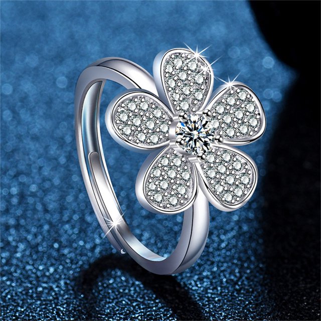 TIMIFIS Rings Knuckle Stacking Rings Fashion Square Blue Diamond Women's Ring with a silver band and a flower-shaped design encrusted with cubic zirconia stones. The ring sparkles against a textured blue background, making it ideal for engagement, wedding, anniversary, casual wear, or as a gift for women and teen girls.