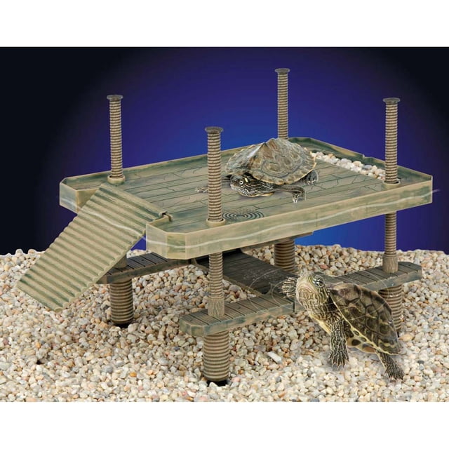 Penn-Plax Penn Plac Reptology Turtle Pier floating basking platform with two turtles, featuring a two-level greenish-brown plastic pier with textured ramp and four suction-cup pylons on gravel substrate, designed for aquatic reptiles in 20-gallon tanks or larger.