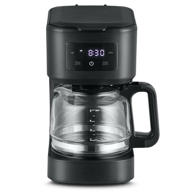 Mainstays 5 Cup Programmable Coffee Maker in black with a front-facing digital touchscreen display showing 8:30 AM, clear glass carafe with 5-cup measurement markings and ergonomic handle, featuring 24-hour programmability, brew pause, and removable brew basket, suitable for small households.
